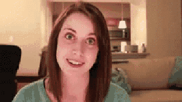 a woman is smiling and looking at the camera while sitting on a couch in a living room .