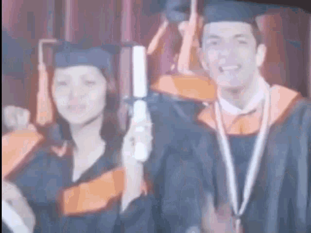 a man and a woman in graduation caps and gowns are standing next to each other .
