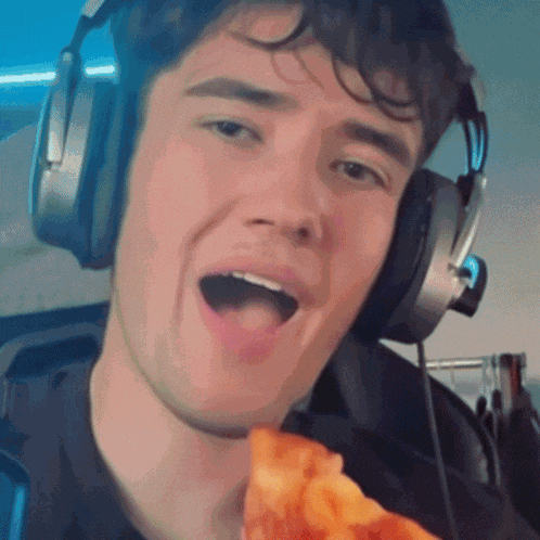 a man wearing headphones holds a slice of pizza