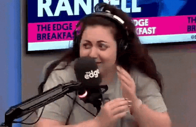 a woman wearing headphones is talking into a microphone at the edge breakfast show