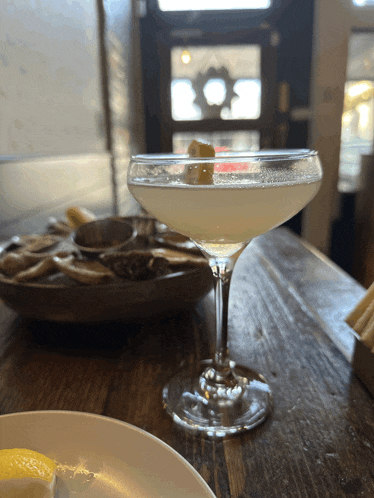 a martini glass with a lemon peel on top of it