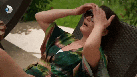 a woman wearing sunglasses is laying in a chair with her hands on her forehead