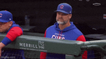 a man wearing a chicago cubs hat and hoodie