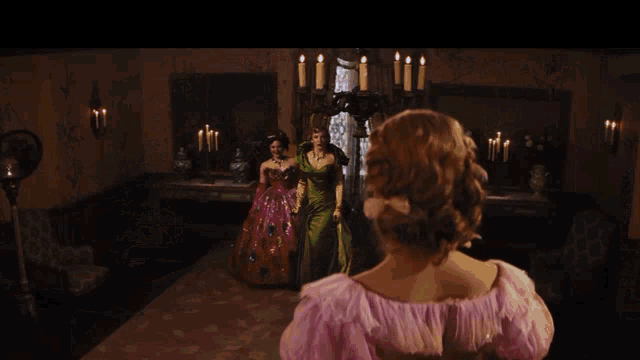 a woman in a pink dress stands in a room