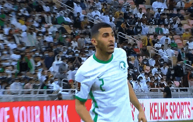 a soccer player in front of a sign that says kelne sports