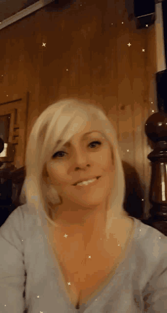 a woman with blonde hair and a plunging neckline is smiling