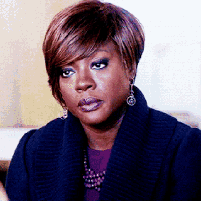 a woman wearing a blue sweater and purple shirt
