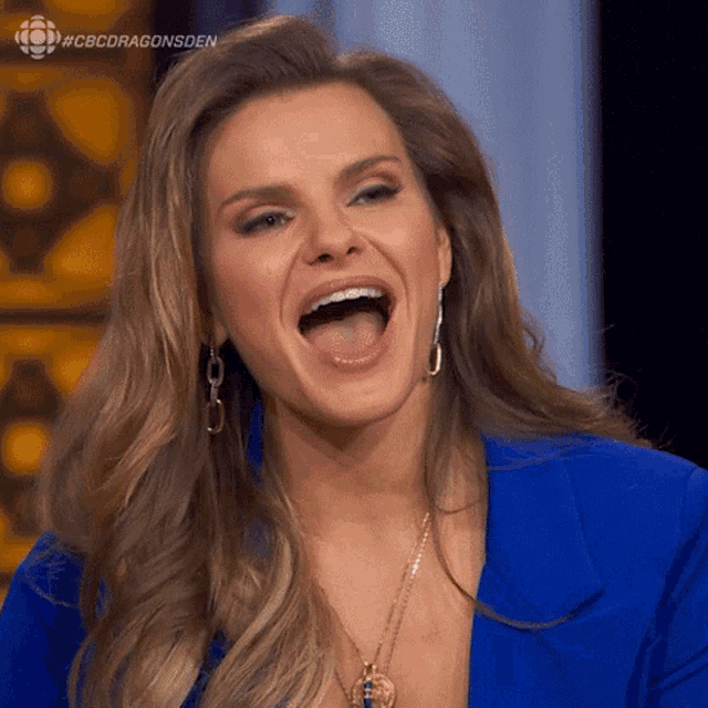 a woman in a blue jacket is laughing with the hashtag #cbcdragonsden on the bottom