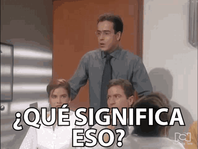 a man in a suit and tie stands in front of a group of people and says que significa eso
