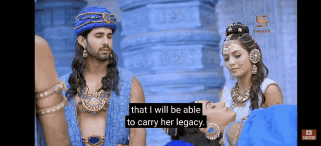 a man in a blue turban is talking to a woman in a blue dress