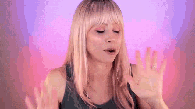 a woman with blonde hair and bangs is making a face with her hands .