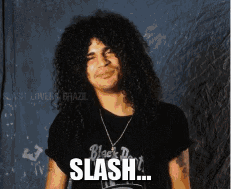 a man with long curly hair is wearing a black shirt that says slash on it