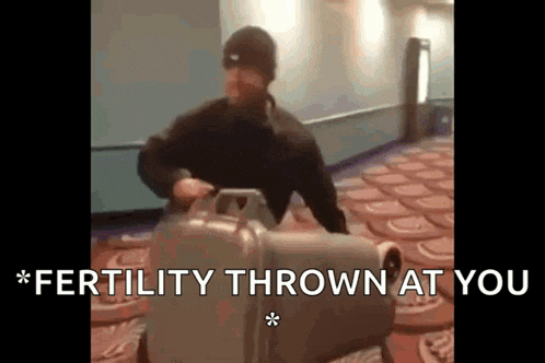 a man is pushing a suitcase that says fertility thrown at you on it