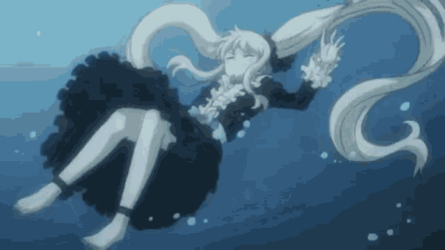 a girl in a black dress is floating in the water with her eyes closed .