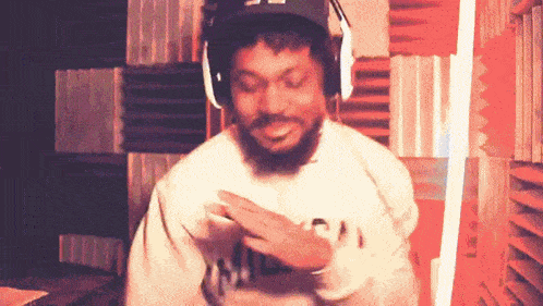 a man with a beard wearing headphones and a hat is dancing .