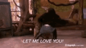 a man is dancing in a room with the words let me love you written on the floor .