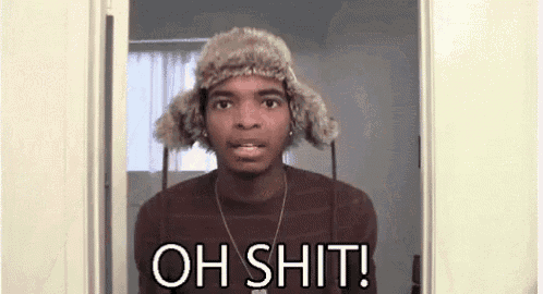 a man wearing a fur hat and a necklace is standing in a doorway and saying `` oh shit ! ''