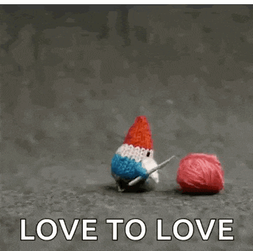 a gnome is knitting while holding a ball of yarn with the words love to love below it .