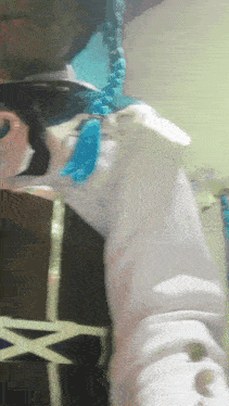 a person wearing a white shirt and a blue necklace