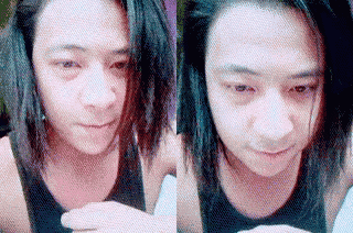 a man with long hair is wearing a black tank top and looking at something .