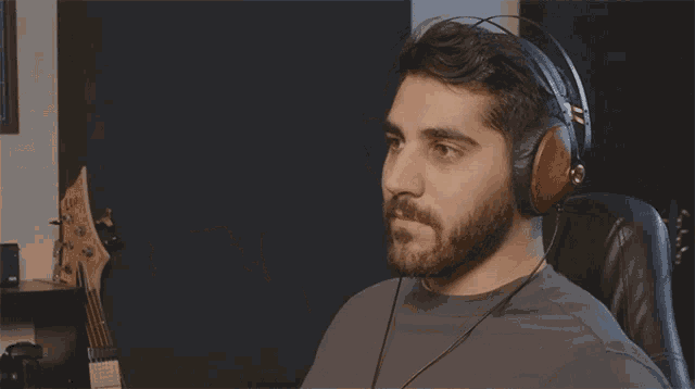 a man wearing headphones is sitting in front of a guitar that says ibanez