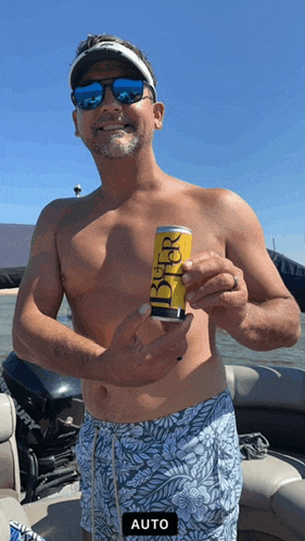 a shirtless man holds a can of beer in his hand