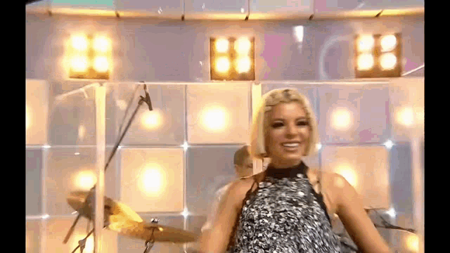 a woman is singing into a microphone on a stage .