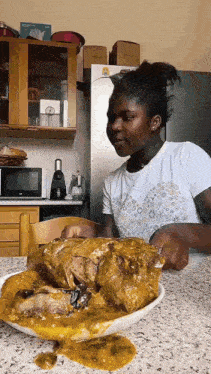 a woman is sitting at a table with a large piece of meat on it