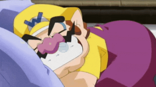 a cartoon character is laying on a bed with a pacifier in his mouth