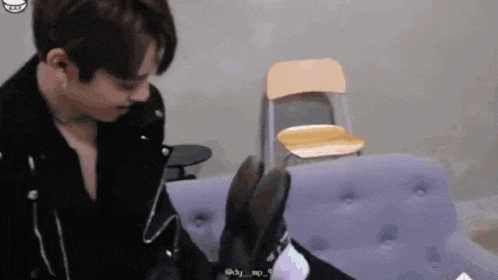a man sitting on a couch with a chair behind him