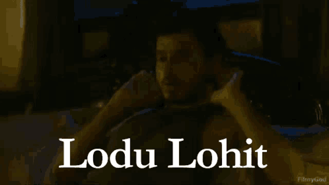 a man is talking on a cell phone with the name lodu lohit written below him