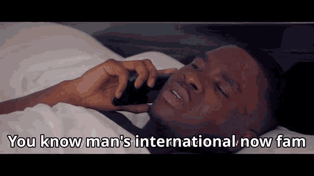 a man laying in bed talking on a cell phone with the words you know man 's international now fam