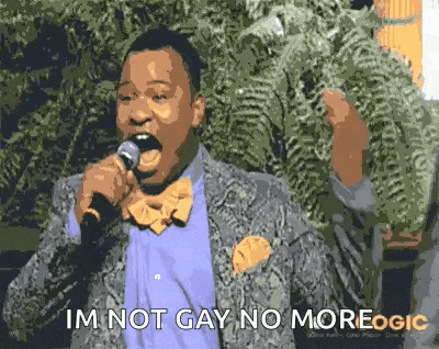 a man in a suit and bow tie is singing into a microphone and says `` i 'm not gay no more . ''