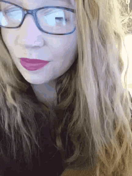 a close up of a woman wearing glasses and red lips