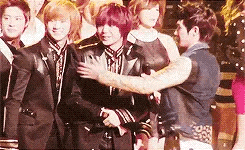 a group of people are standing next to each other and one of them is hugging another person .