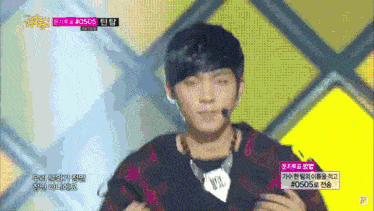 a young man is on a stage with a microphone and the number 0505 on the screen