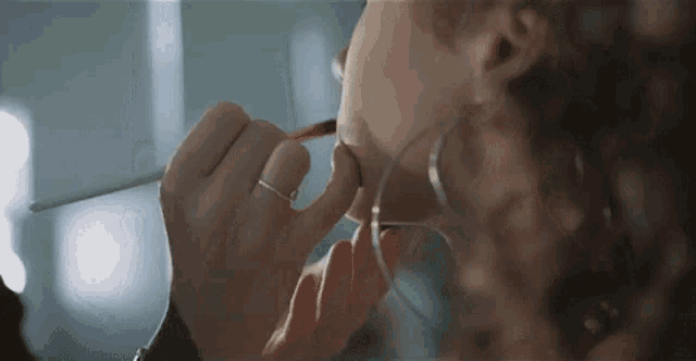 a woman is applying makeup to a mannequin 's face .