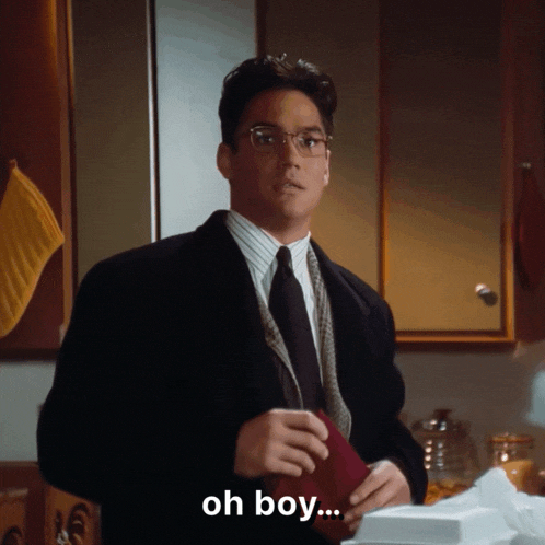a man in a suit and tie is standing in a kitchen and says oh boy