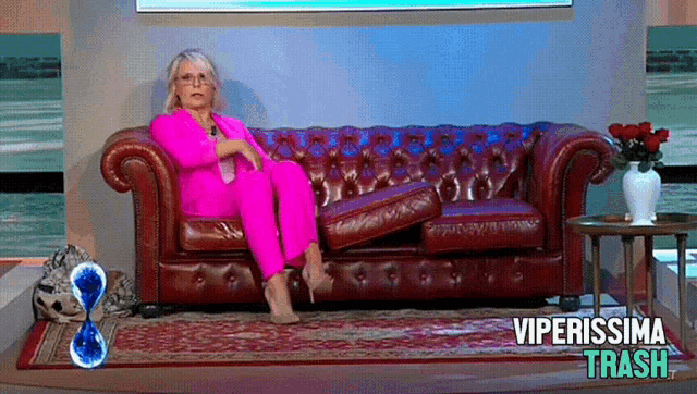 a woman in a pink suit sits on a couch with the words viperissima trash written on the bottom