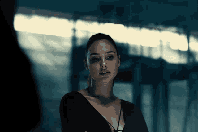 a woman in a black top looks at the camera