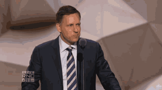 a man in a suit and tie stands in front of a microphone with the words live rnc on the bottom