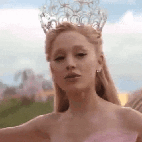 a woman in a pink dress and a crown on her head .
