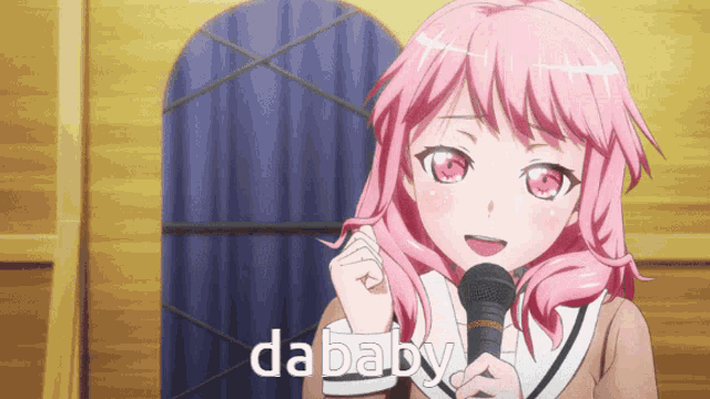 a girl with pink hair is singing into a microphone and the word dababy is on the bottom right