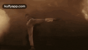 two men are fighting in a dark room with smoke coming out of the walls .