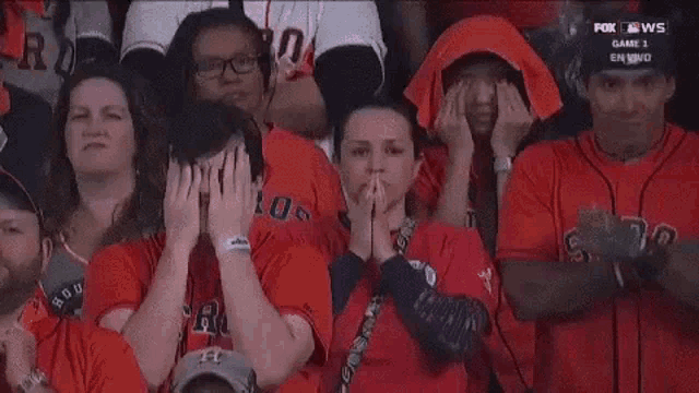 a group of people are sitting in a stadium watching a baseball game .