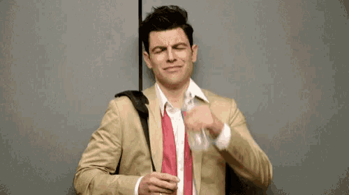 a man in a suit and tie is holding a bottle of water and crying .