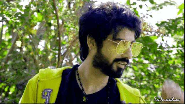 a man with a beard wearing sunglasses and a yellow jacket with the number 9 on the back