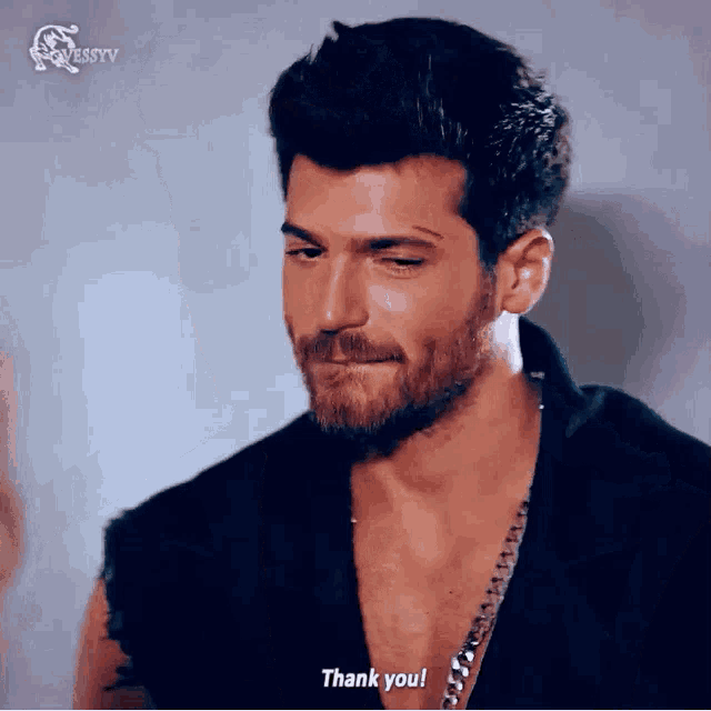 a man with a beard wearing a black shirt is saying thank you