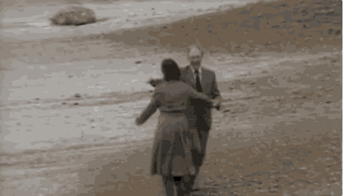 a man and a woman are walking on a dirt road .