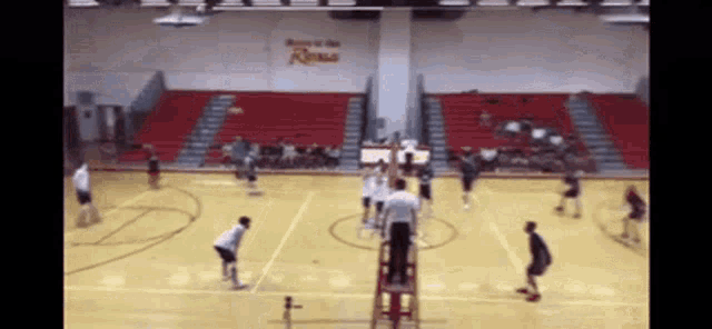 a volleyball game is being played in a gym with the word kings on the wall above the court